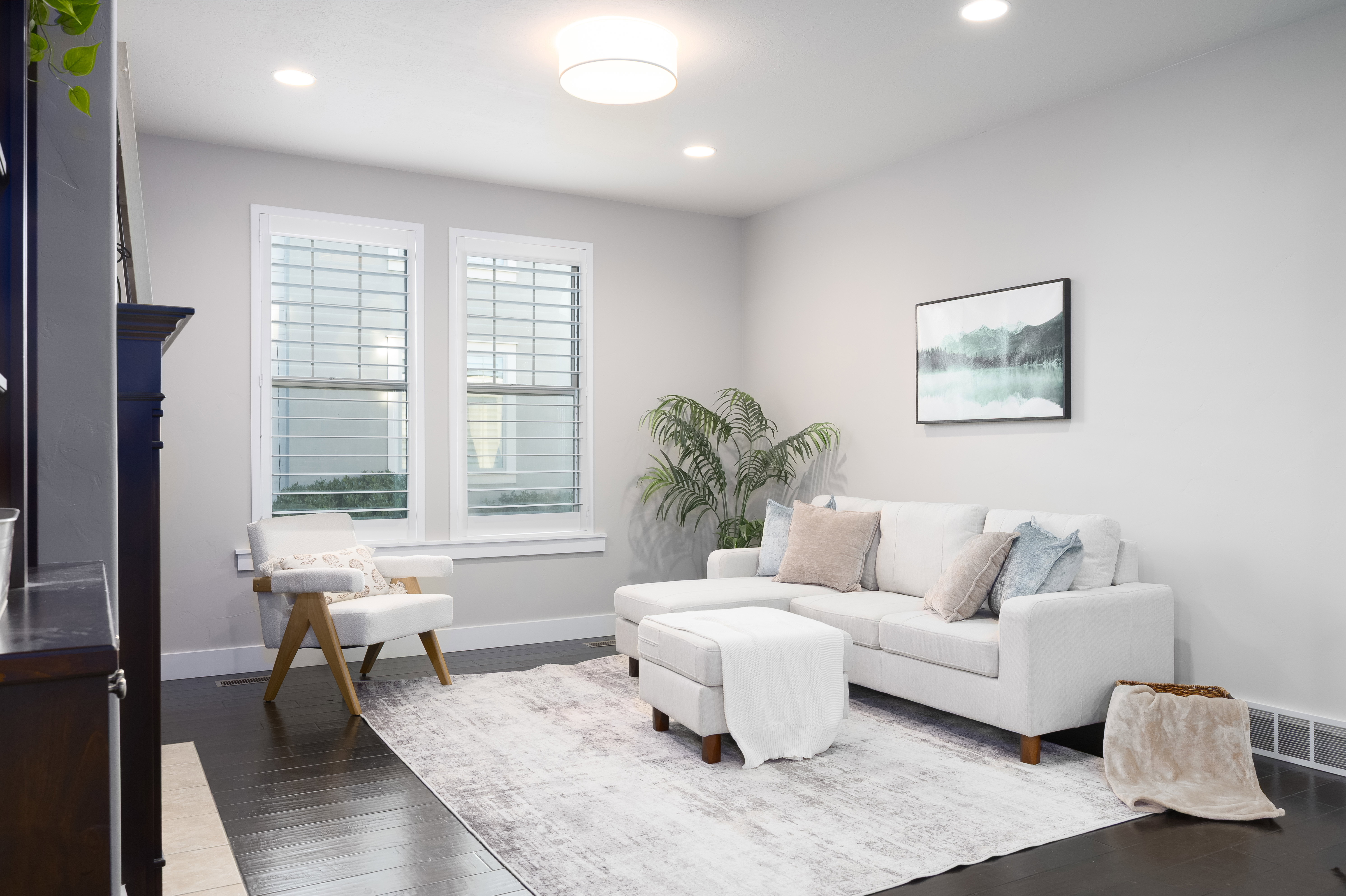 Bright living space featuring dark wood-finish flooring, light grey walls, and recessed ceiling lighting