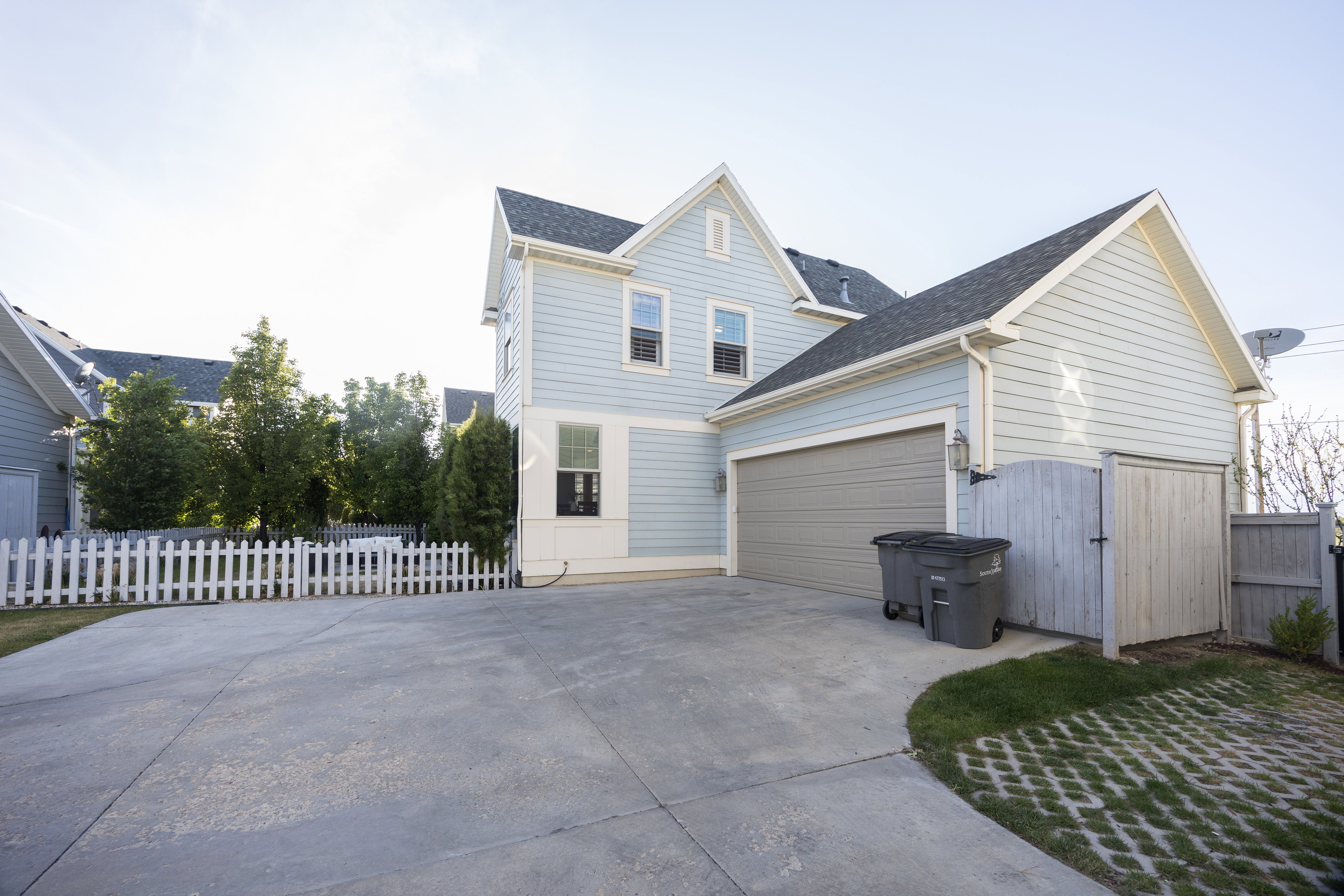 Two-story residence featuring light blue siding and a dark shingle roof