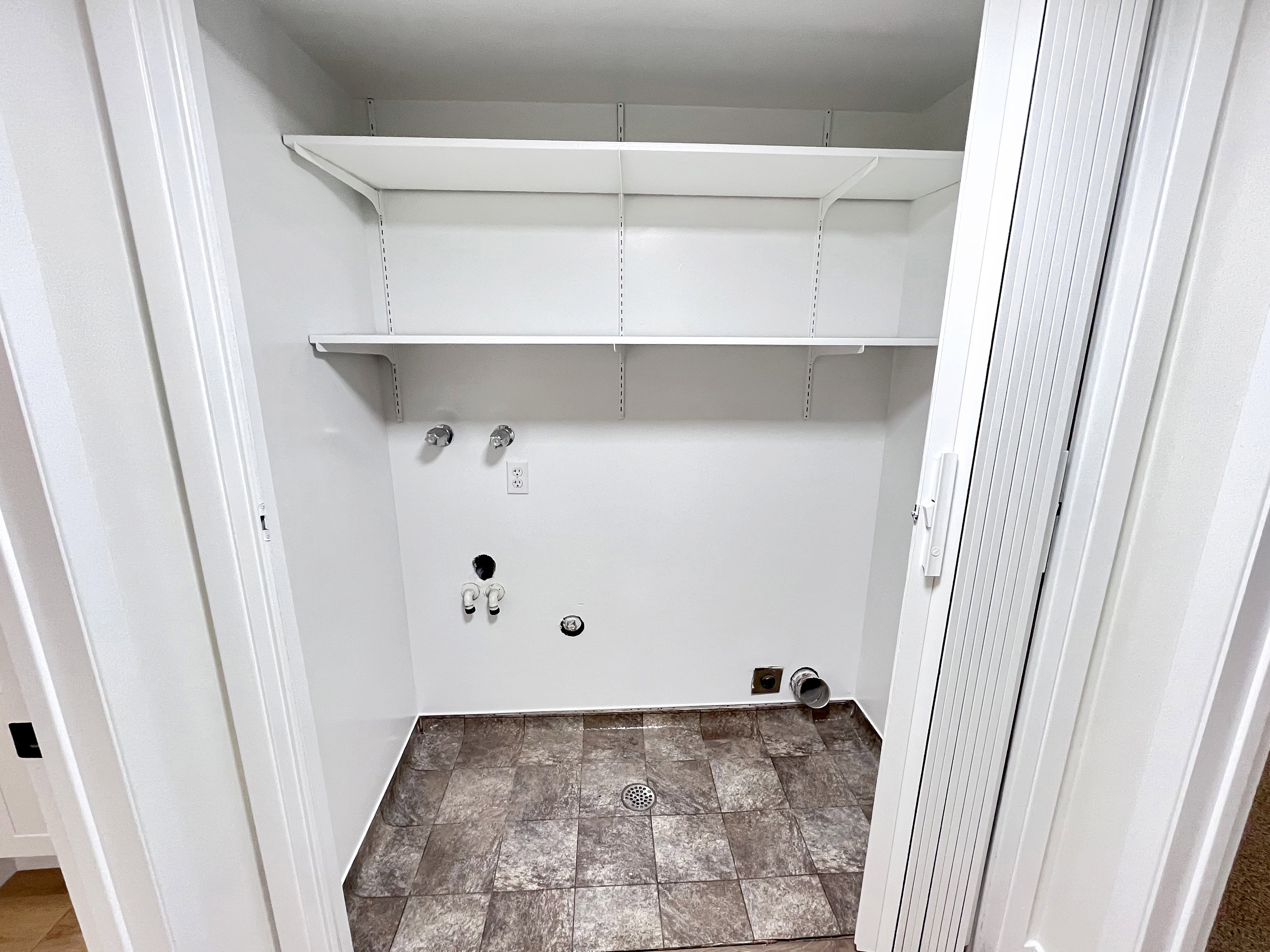 Laundry area featuring easy to clean flooring, hookup for a washing machine, and electric dryer hookup, and shelves for storage