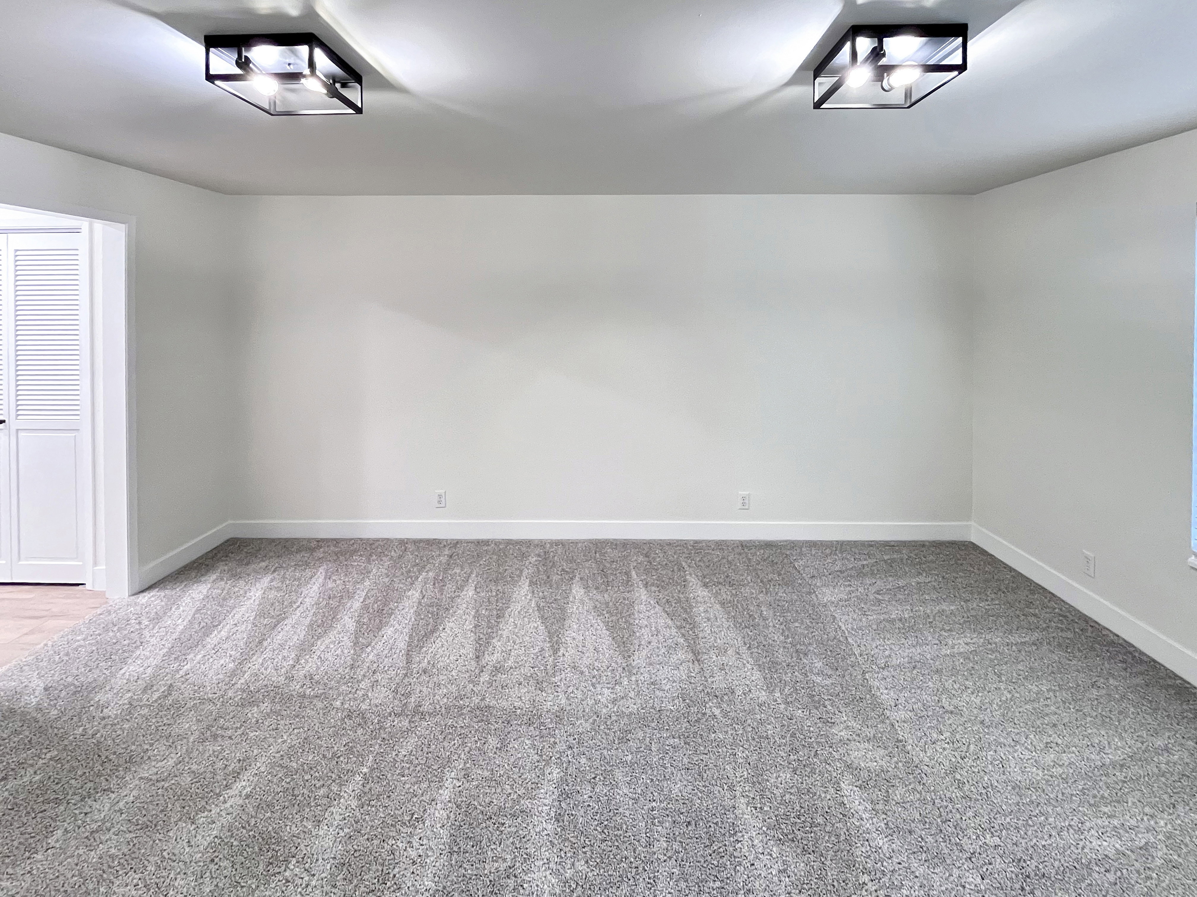 Primary Bedroom featuring tall baseboards, cozy plush carpet, warm tones, and convenient bathroom