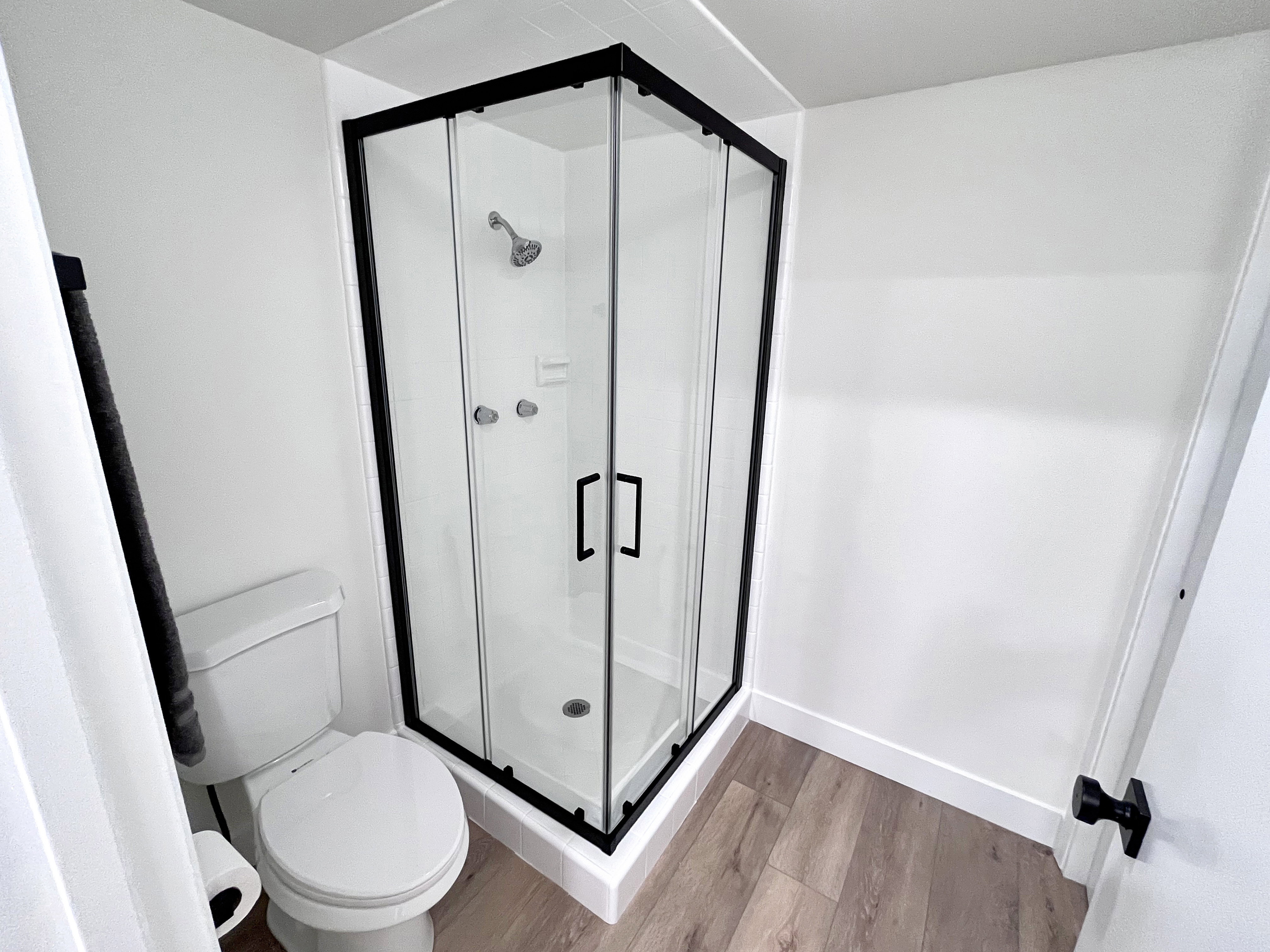 Primary full bathroom featuring wood finished floors, shower, and additional closet space