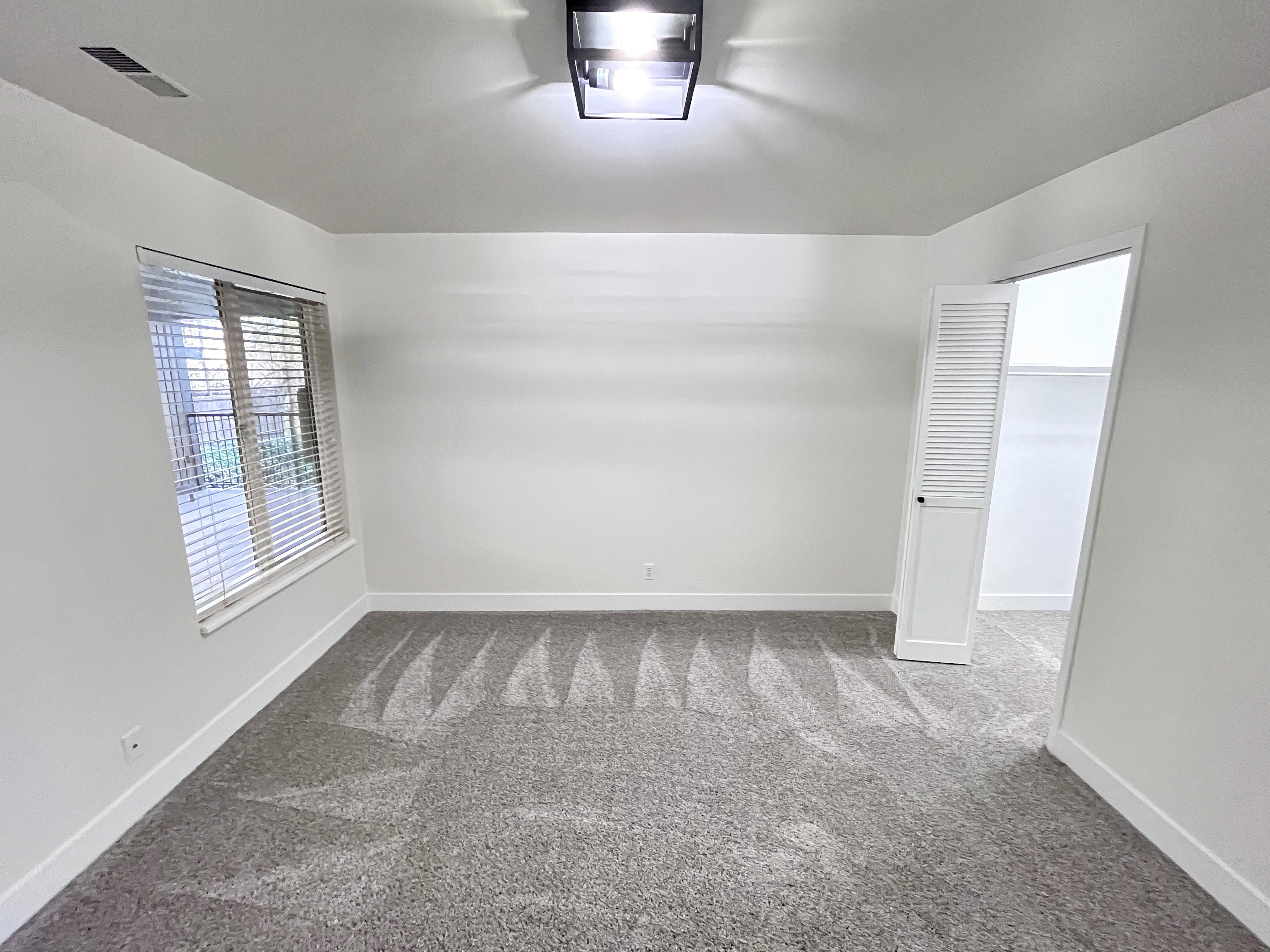 Second Bedroom featuring tall baseboards, cozy plush carpet, warm tones, and convenient bathroom access through a walk-in closet