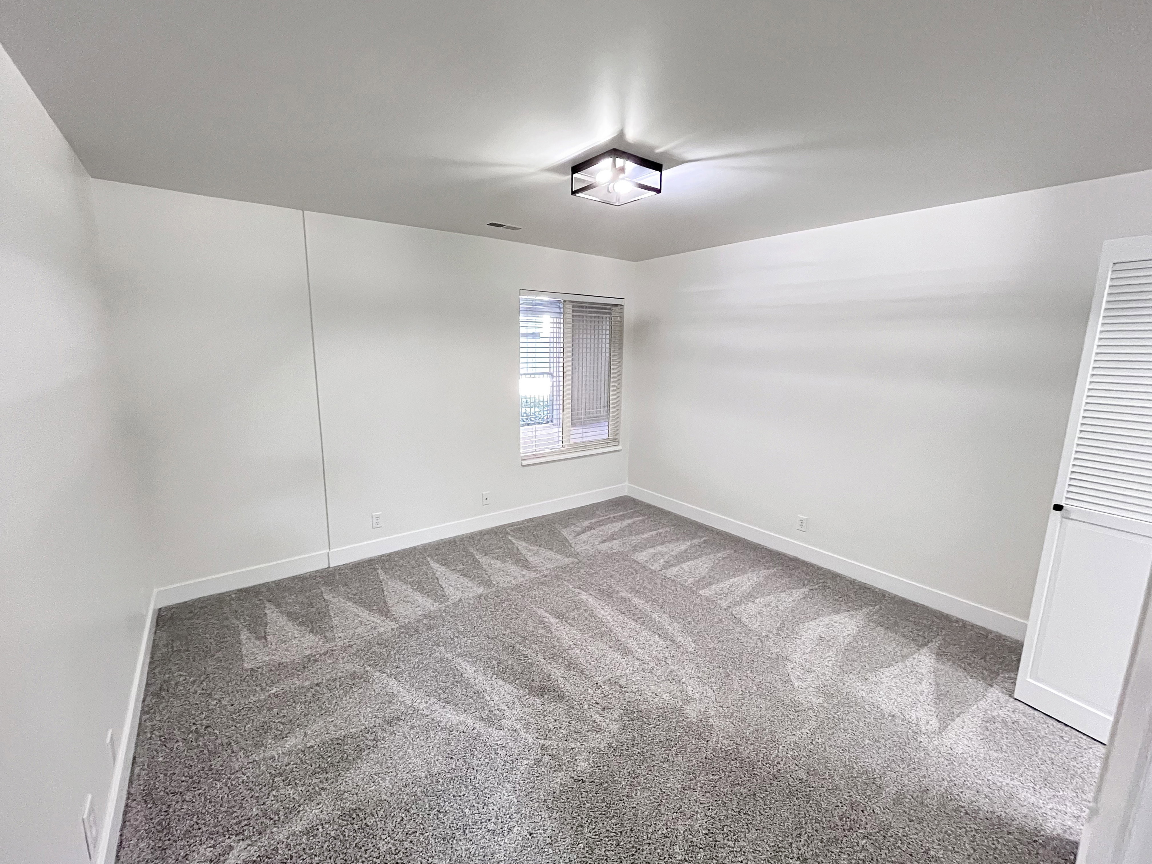 Second Bedroom featuring tall baseboards, cozy plush carpet, warm tones, and convenient bathroom access through a walk-in closet