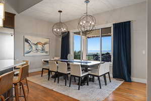 Formal dining area featuring rich wood-finish flooring, a large area rug, and two spherical pendant light fixtures