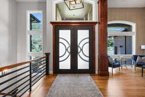Grand entry featuring a double door with decorative glass, rich wood-finish trim, and a transom window