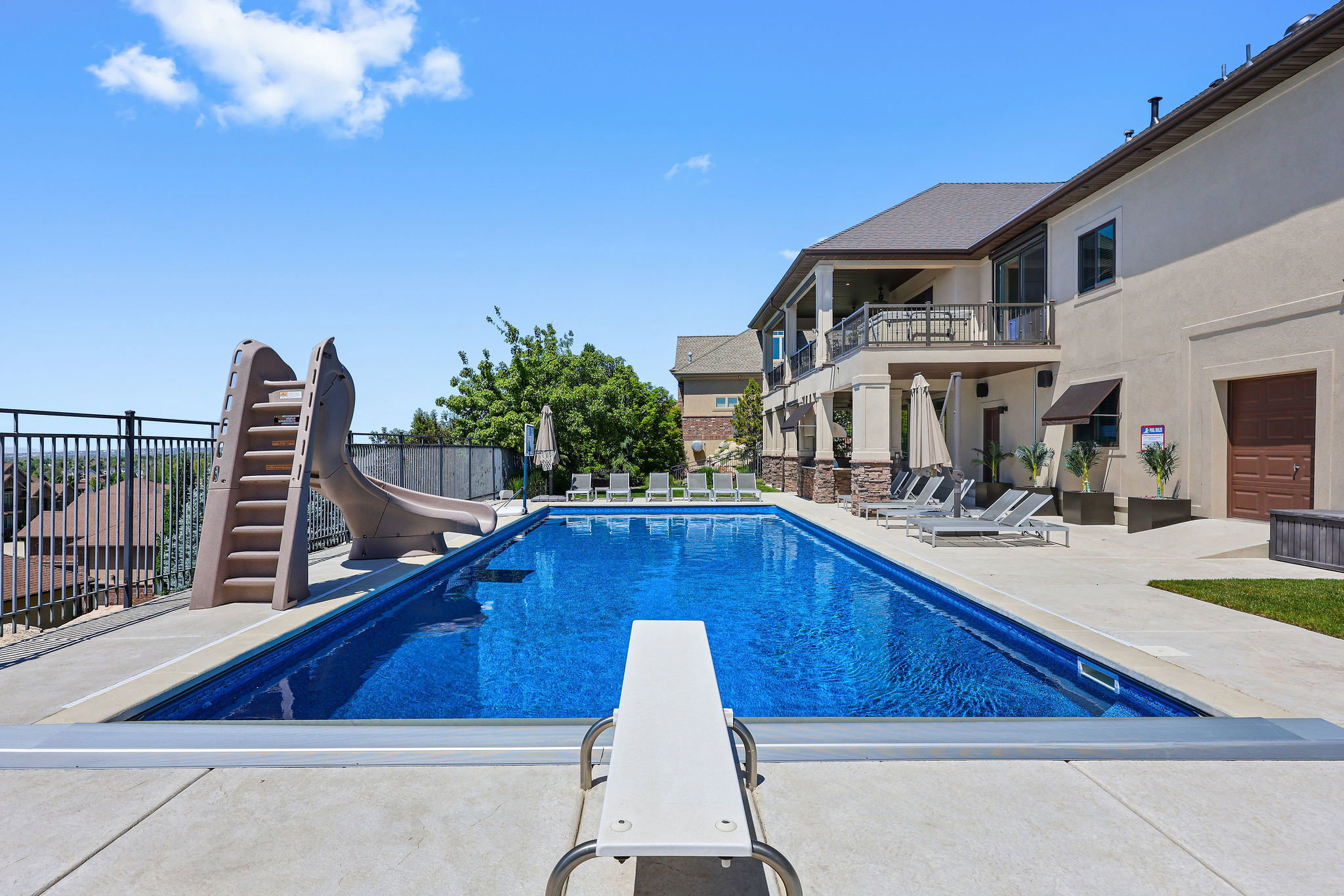Rectangular in-ground pool with a diving board and attached slide