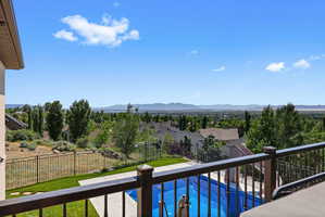 Outdoor living space featuring a swimming pool with integrated slide, concrete patio, and wrought iron railing