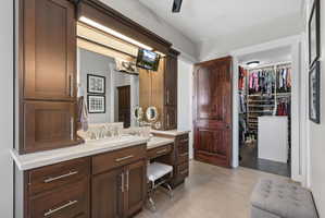 Bathroom vanity featuring dark wood cabinetry, a light-toned countertop, and dual sinks