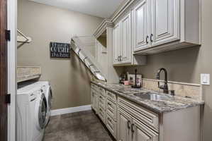 Dedicated laundry room featuring wood-finish flooring and a stone countertop