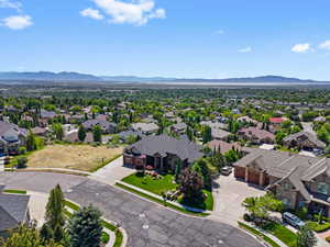 Expansive residential area featuring numerous properties amidst extensive greenery and distant mountain ranges