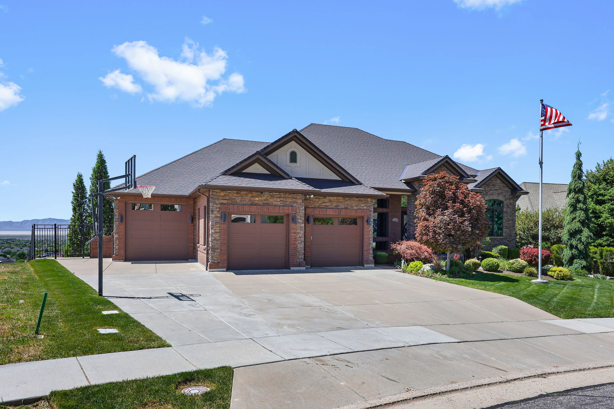 Brick and stone exterior with a dark shingle roof