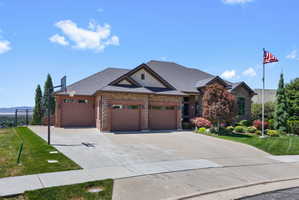 Brick and stone exterior with a dark shingle roof