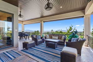 Expansive covered patio featuring a textured concrete floor and wood-finish ceiling