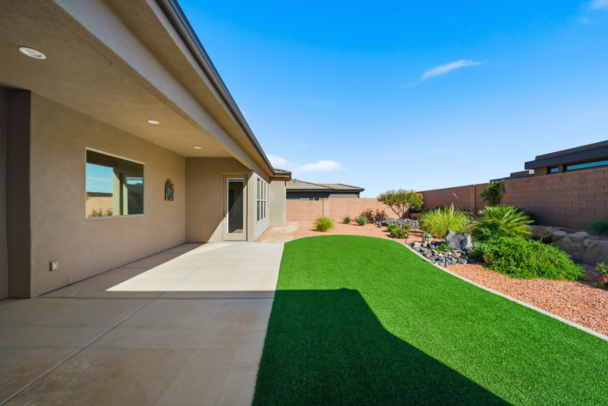 Expansive covered patio featuring recessed lighting, a stucco exterior, and a glass-paneled door