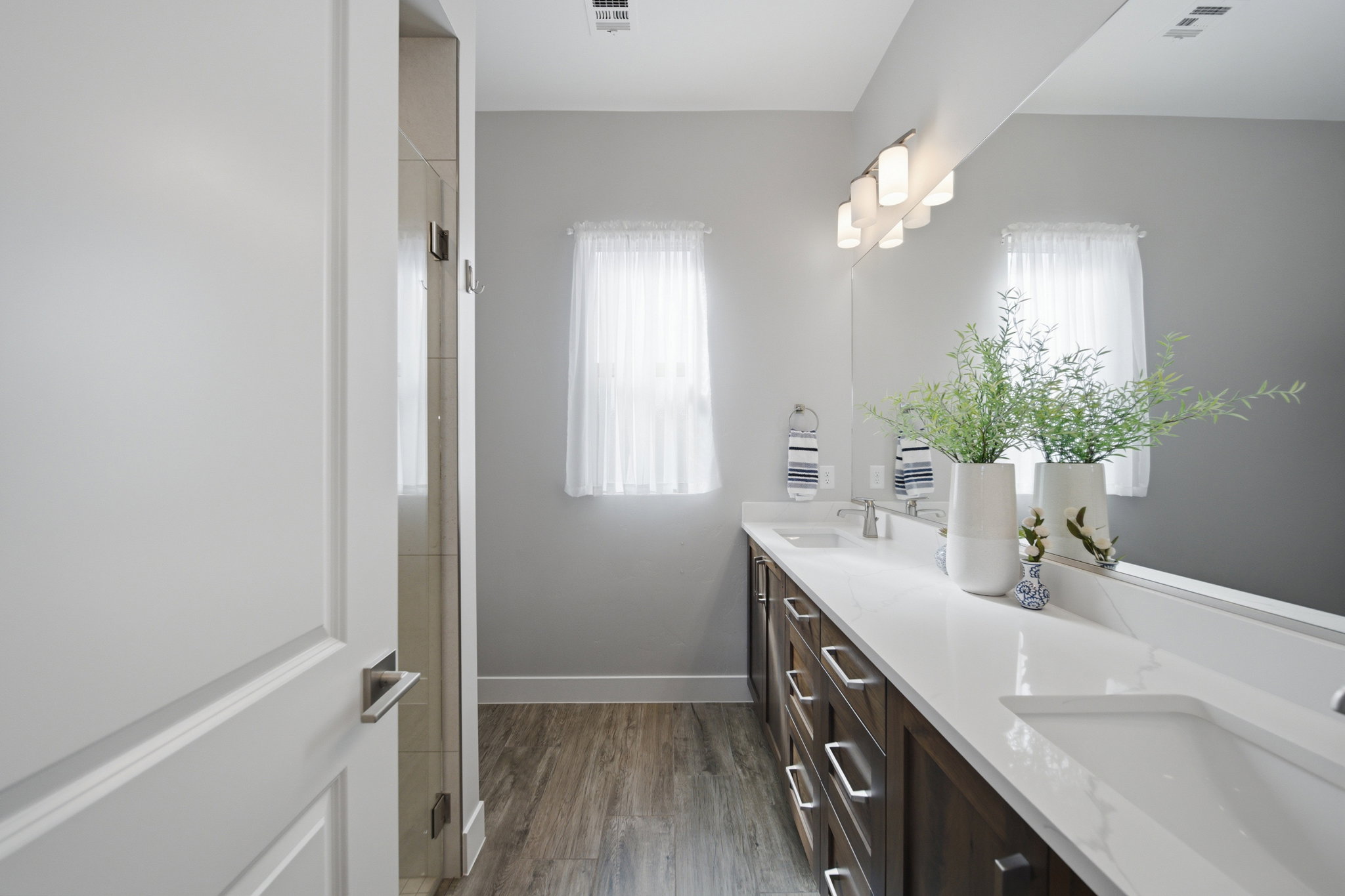 Double vanity with integrated sinks, white countertops, and dark wood-finish cabinetry