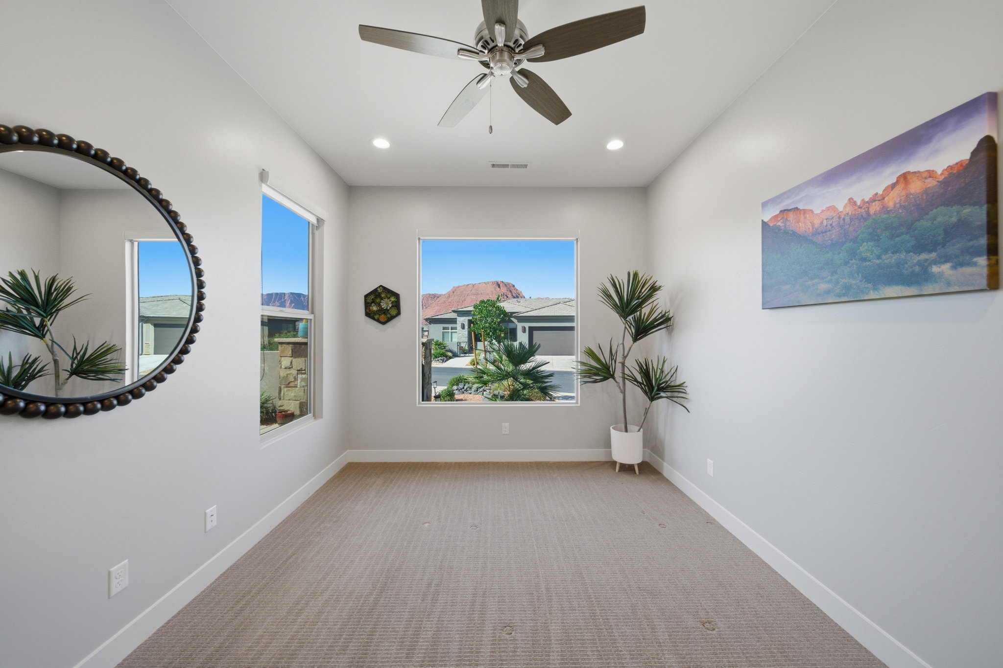 Spacious room featuring multiple windows, recessed lighting, a ceiling fan, and light-toned carpeting