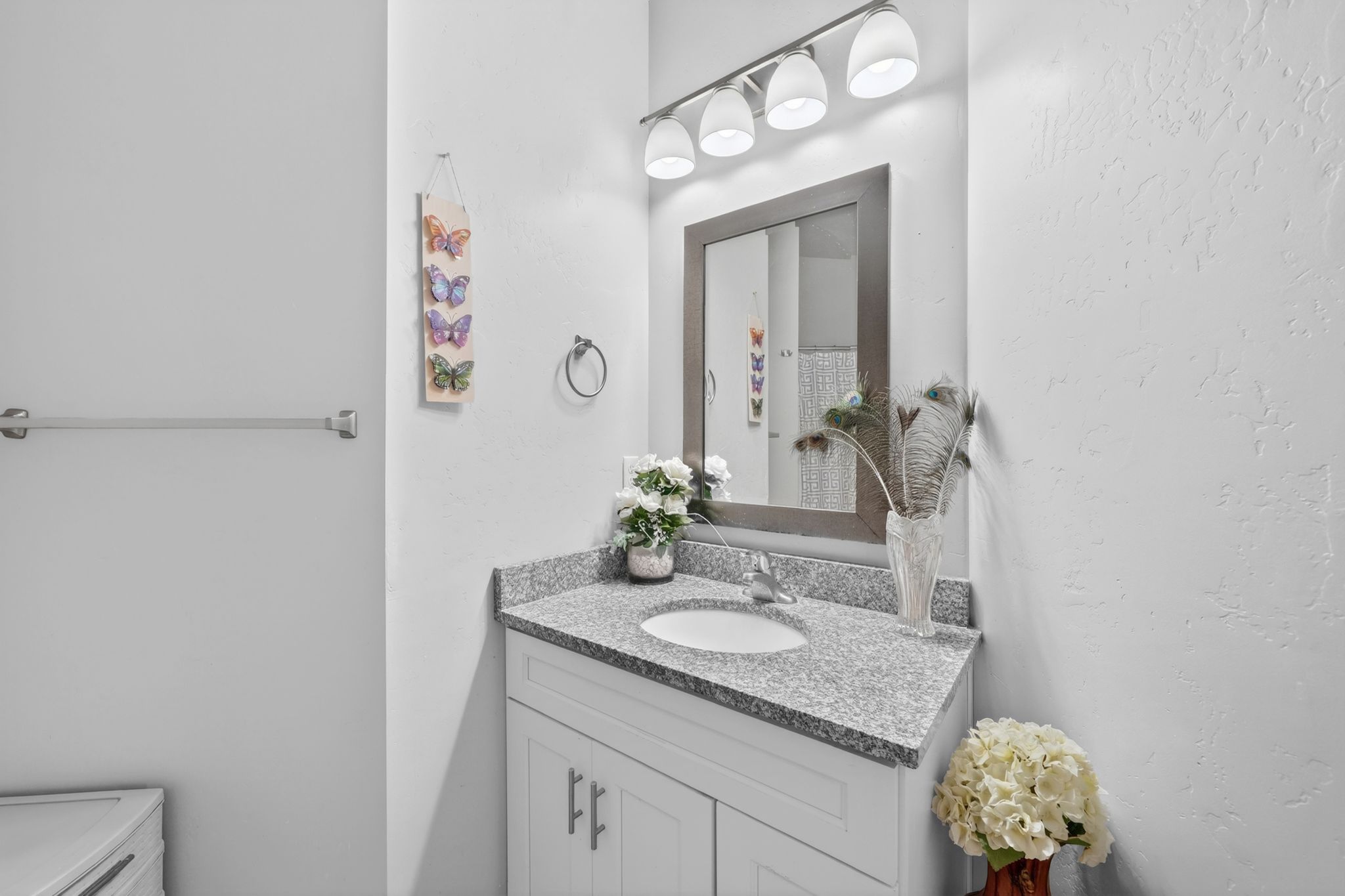 Bathroom vanity with a gray granite-style countertop, integrated white sink, and chrome faucet