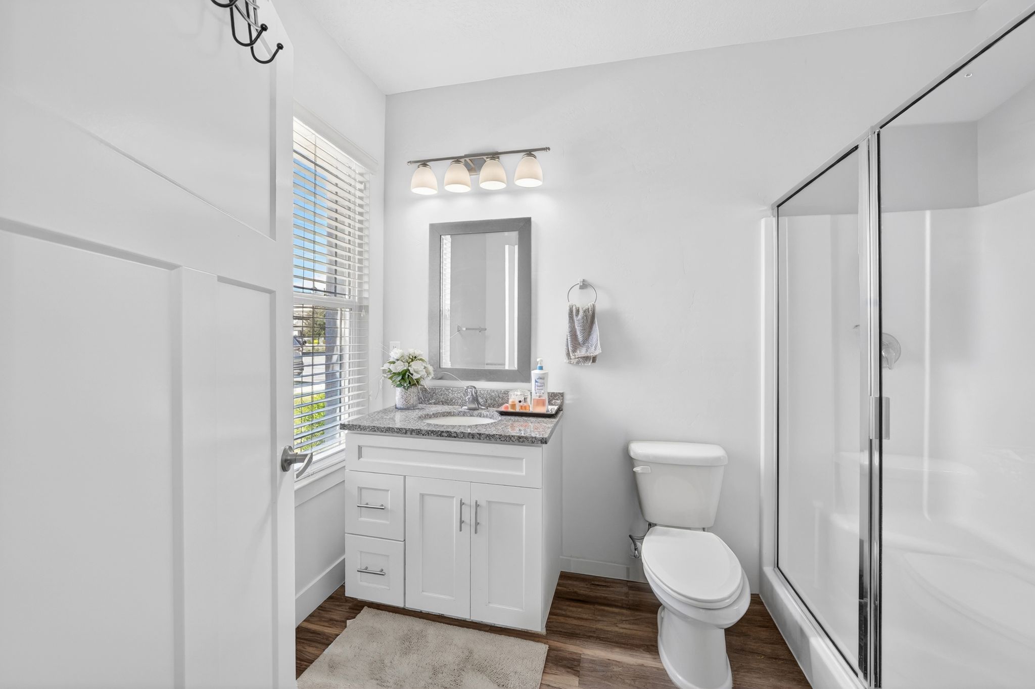 Bathroom featuring a white vanity with a stone-finish countertop, undermount sink, and chrome faucet