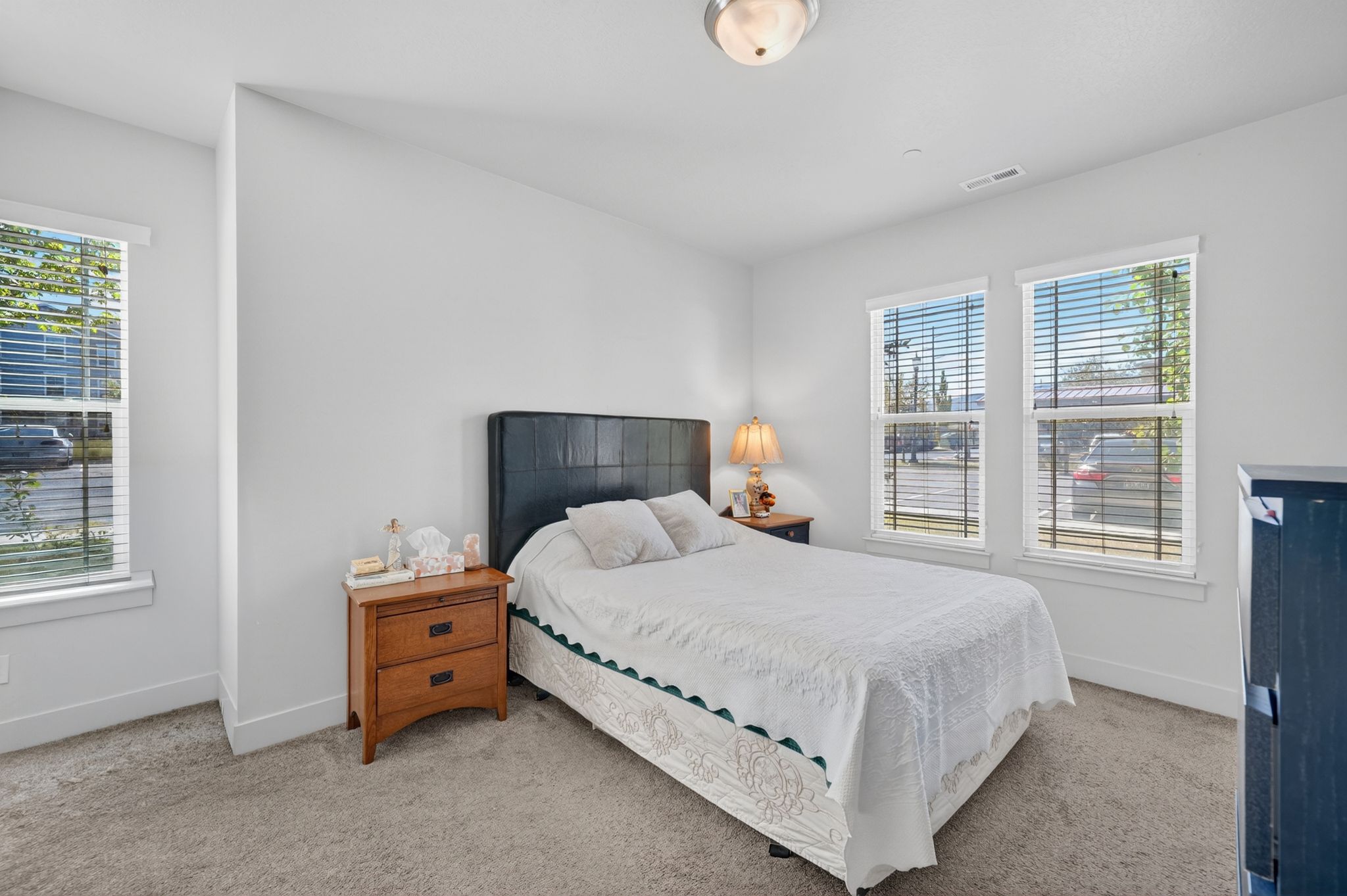 Bedroom featuring plush carpet, white walls, and a contemporary ceiling light fixture