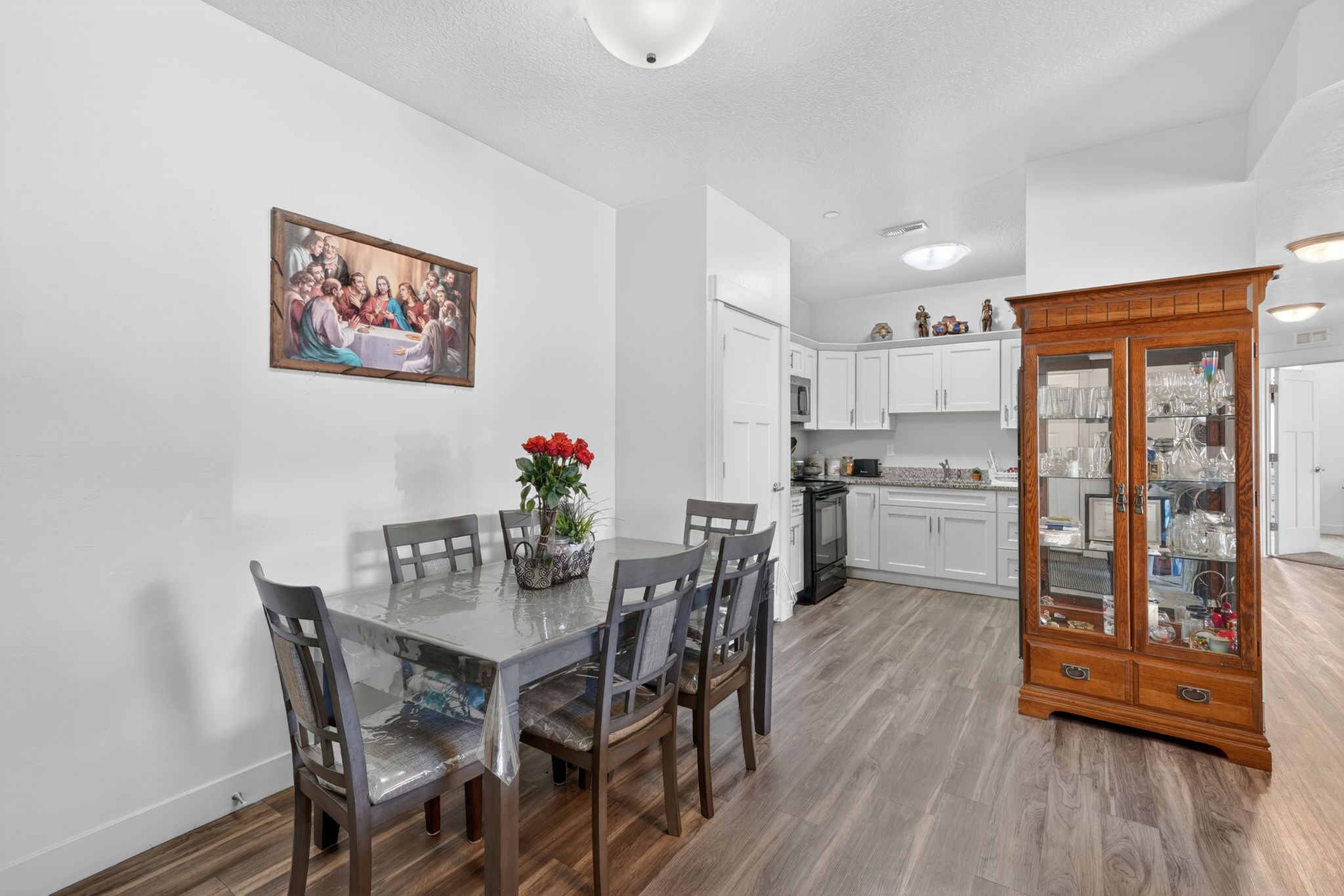 Open-concept living space featuring wood-finish flooring, white walls, and a recessed ceiling light
