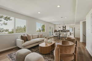 Open-concept living area featuring wood-finish flooring, recessed lighting, and expansive windows