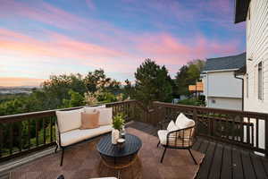 Spacious outdoor deck featuring dark wood-finish flooring, a full perimeter railing, and distant mountain scenery
