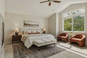 Spacious bedroom with vaulted ceilings, a prominent window array, and a ceiling fan