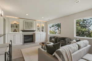 Integrated fireplace with a tile surround, flanked by custom built-in cabinetry and shelving