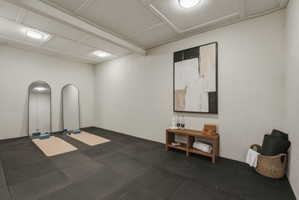 Dedicated room featuring interlocking floor mats, two arched full-length mirrors, and recessed lighting
