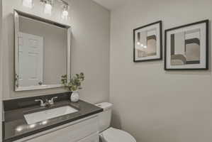 Bathroom vanity featuring a dark countertop, an undermount sink, and a chrome faucet
