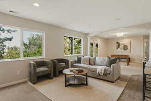 Spacious lower-level area with multiple large windows and recessed lighting