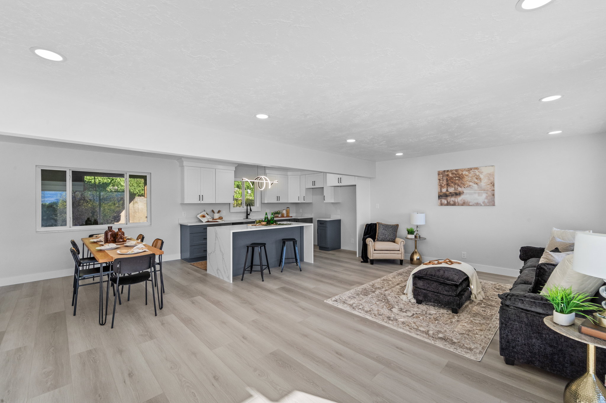 Open-concept living space featuring wood-finish flooring, recessed lighting, and a modern kitchen