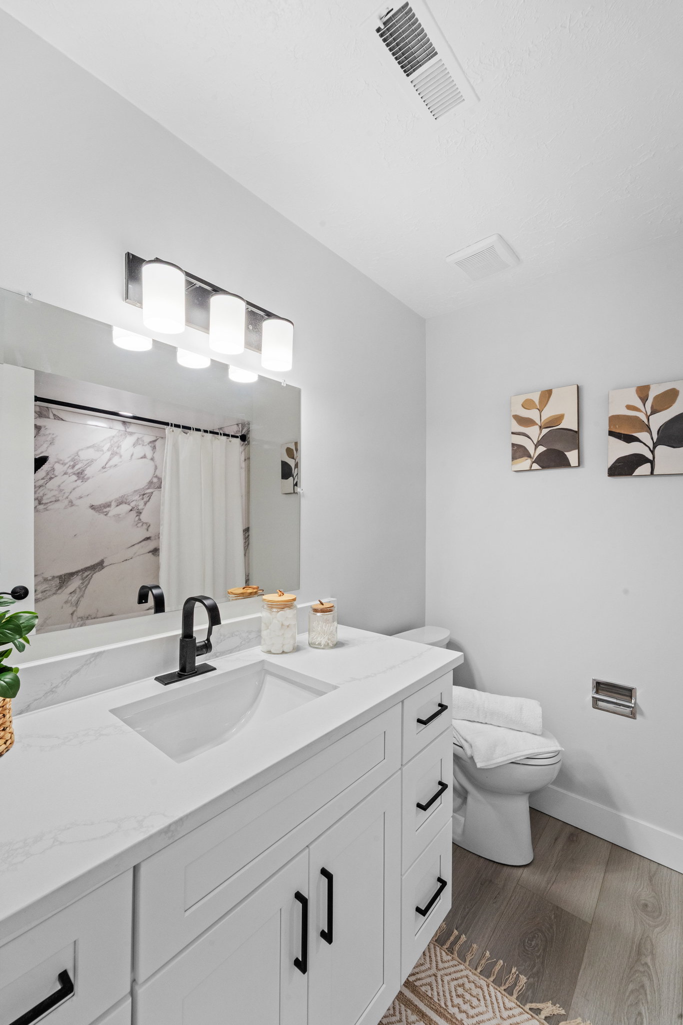 Modern bathroom featuring a white vanity with integrated sink, matte black faucet, and quartz-finish countertop