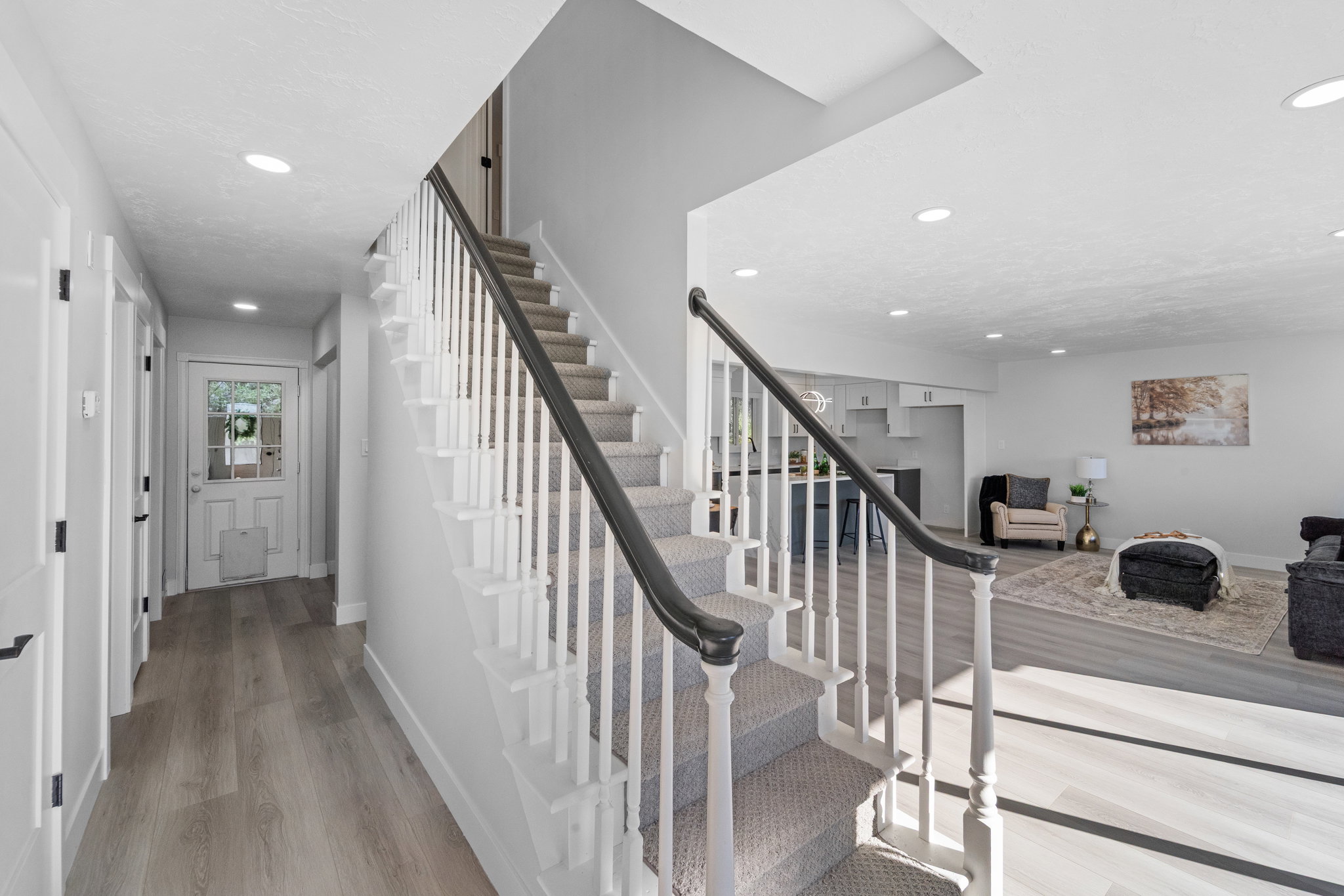 Carpeted staircase with dark handrail and white balusters