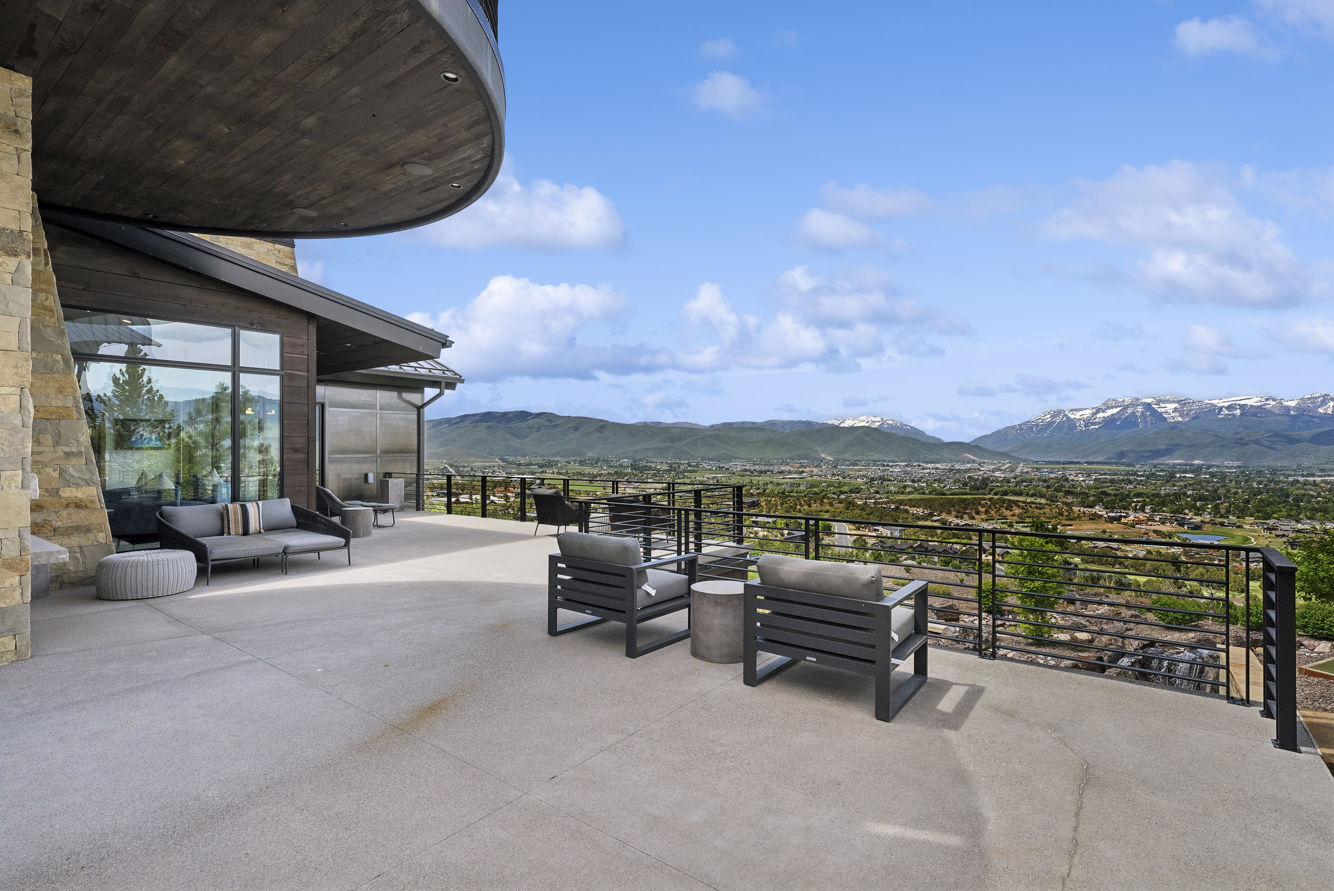 Spacious outdoor patio with stone facade and dark wood paneling
