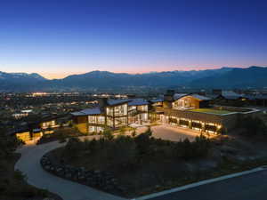 Expansive contemporary residence featuring a multi-level design with extensive glazing, a multi-car garage, and a lush green rooftop space