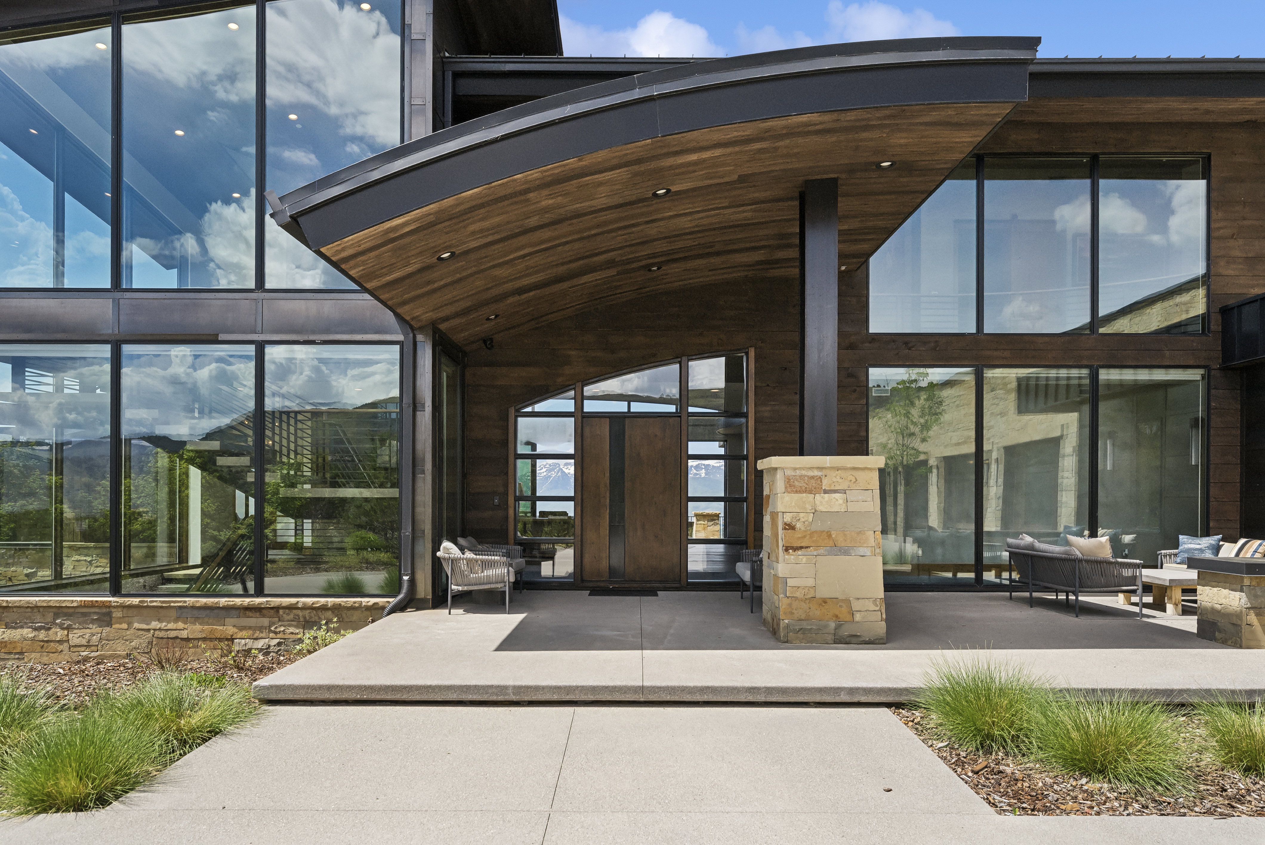Modern architectural exterior with extensive glass paneling and wood-finish siding