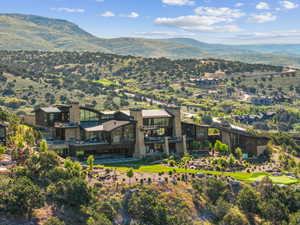 Extensive contemporary estate featuring stone and dark wood-tone exterior finishes