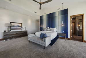 Bedroom featuring a vaulted ceiling and a large padded headboard wall