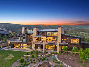Expansive contemporary residence featuring a multi-level design, wood and stone exterior finishes, and large windows