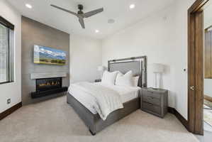 Bedroom featuring a textured accent wall with an integrated linear fireplace and mounted television