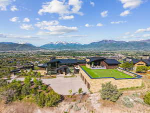 Modern mountain residence with a multi-car garage, expansive putting green, and stone exterior
