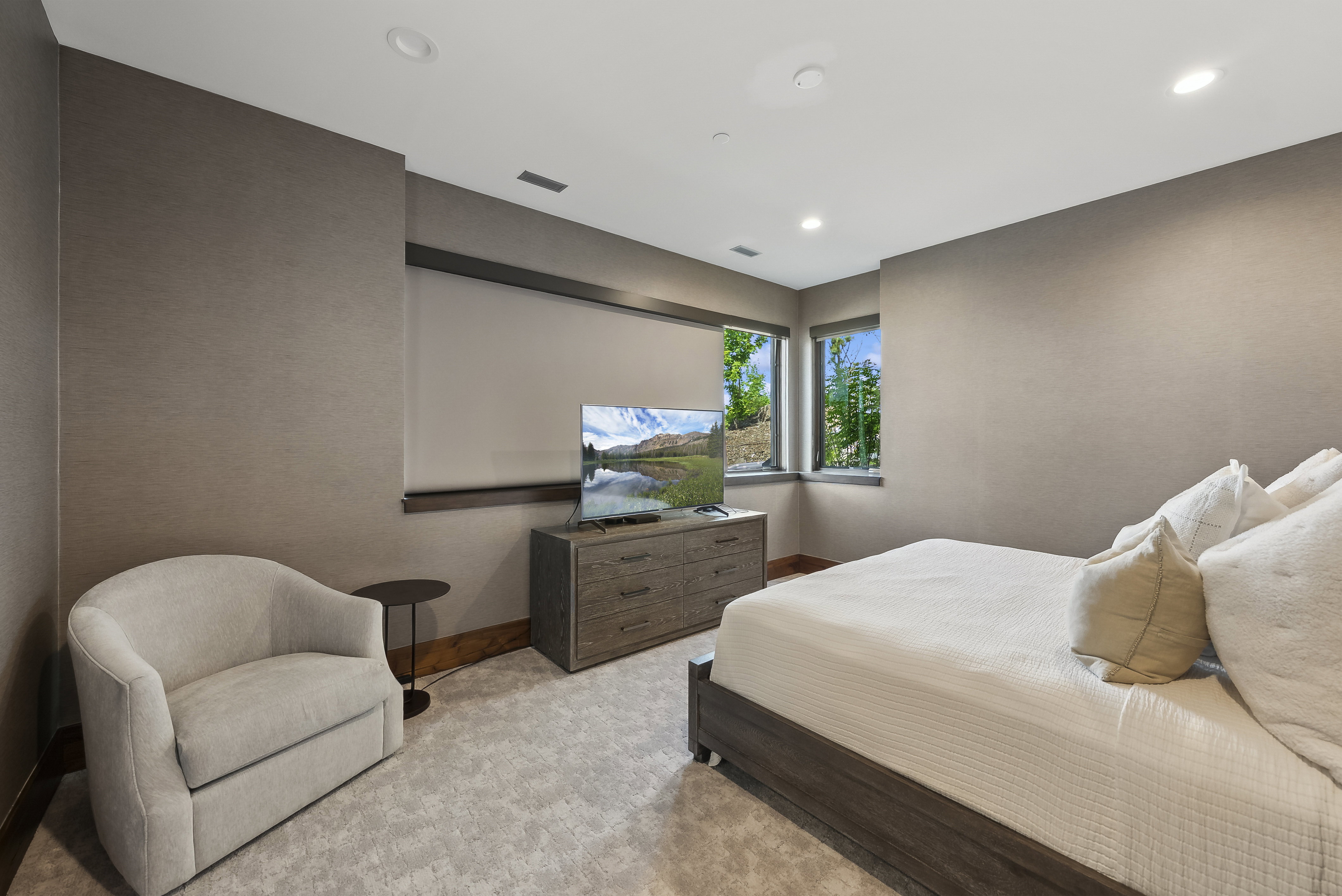 Spacious room featuring textured wall coverings, recessed lighting, and large windows with natural scenery