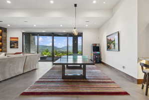 Open-concept room featuring floor-to-ceiling sliding glass doors, recessed lighting, and a stone accent wall with built-in shelving