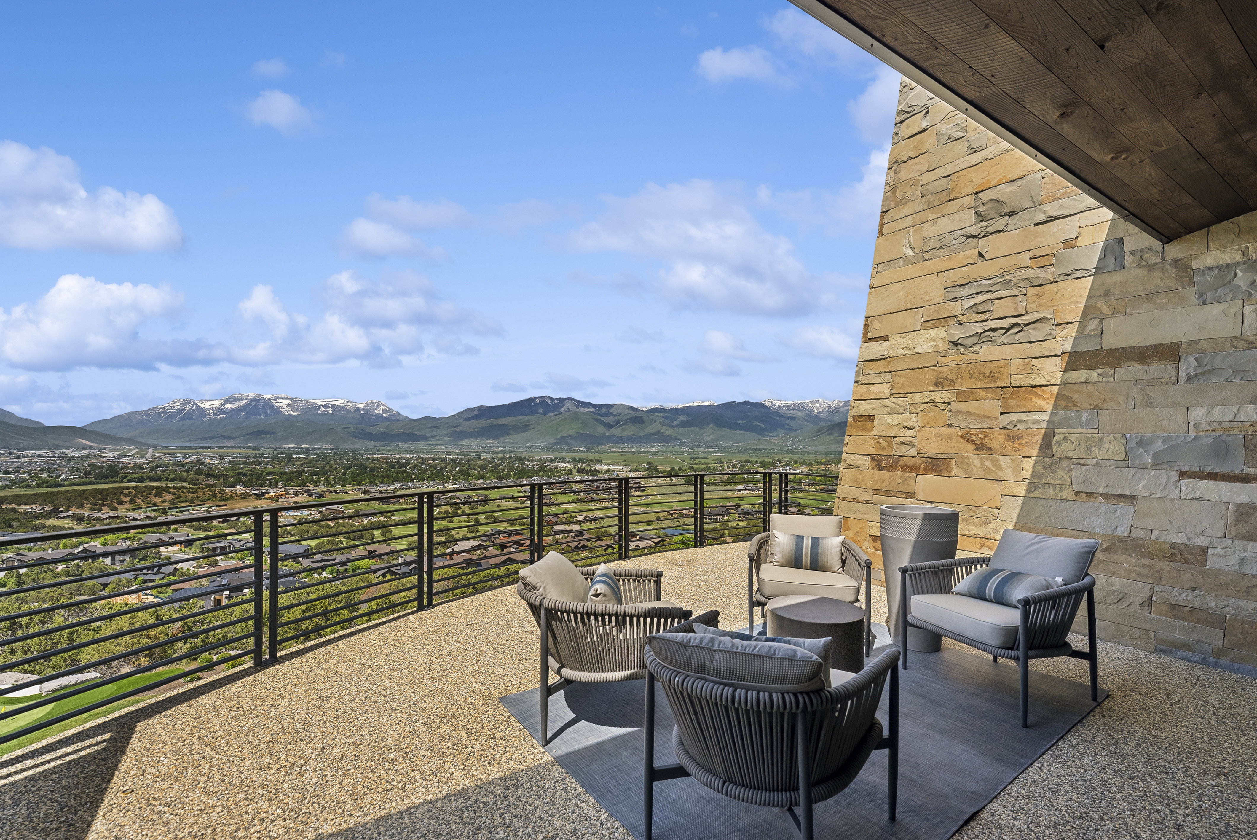 Terrace featuring a stone accent wall, wood-paneled ceiling, and a gravel-textured floor
