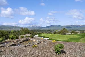 Private putting green with multiple holes, sand traps, and a surrounding natural landscape