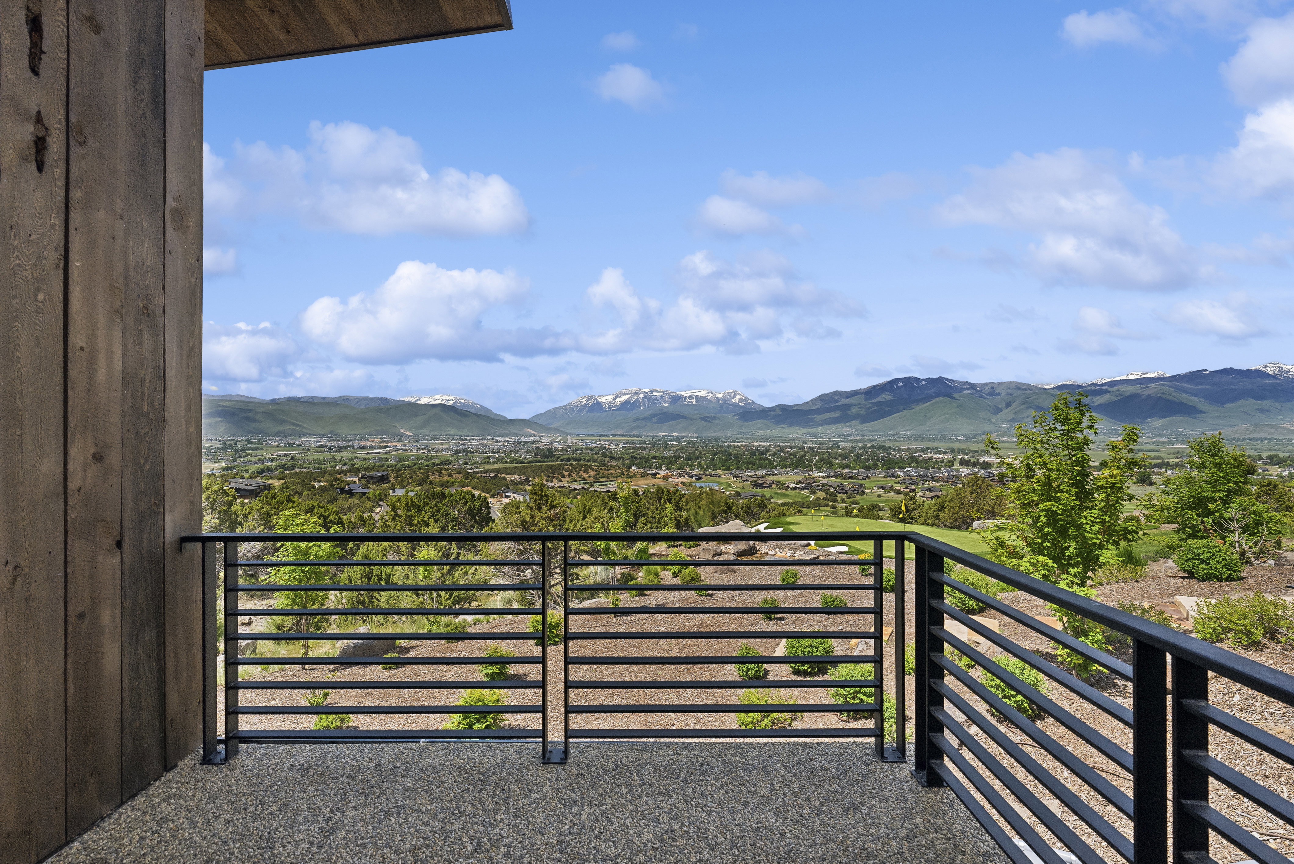 Expansive balcony with black horizontal bar railings and a textured aggregate surface