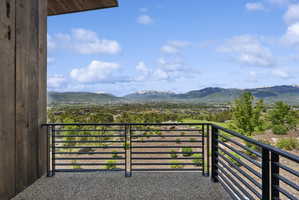 Expansive balcony with black horizontal bar railings and a textured aggregate surface