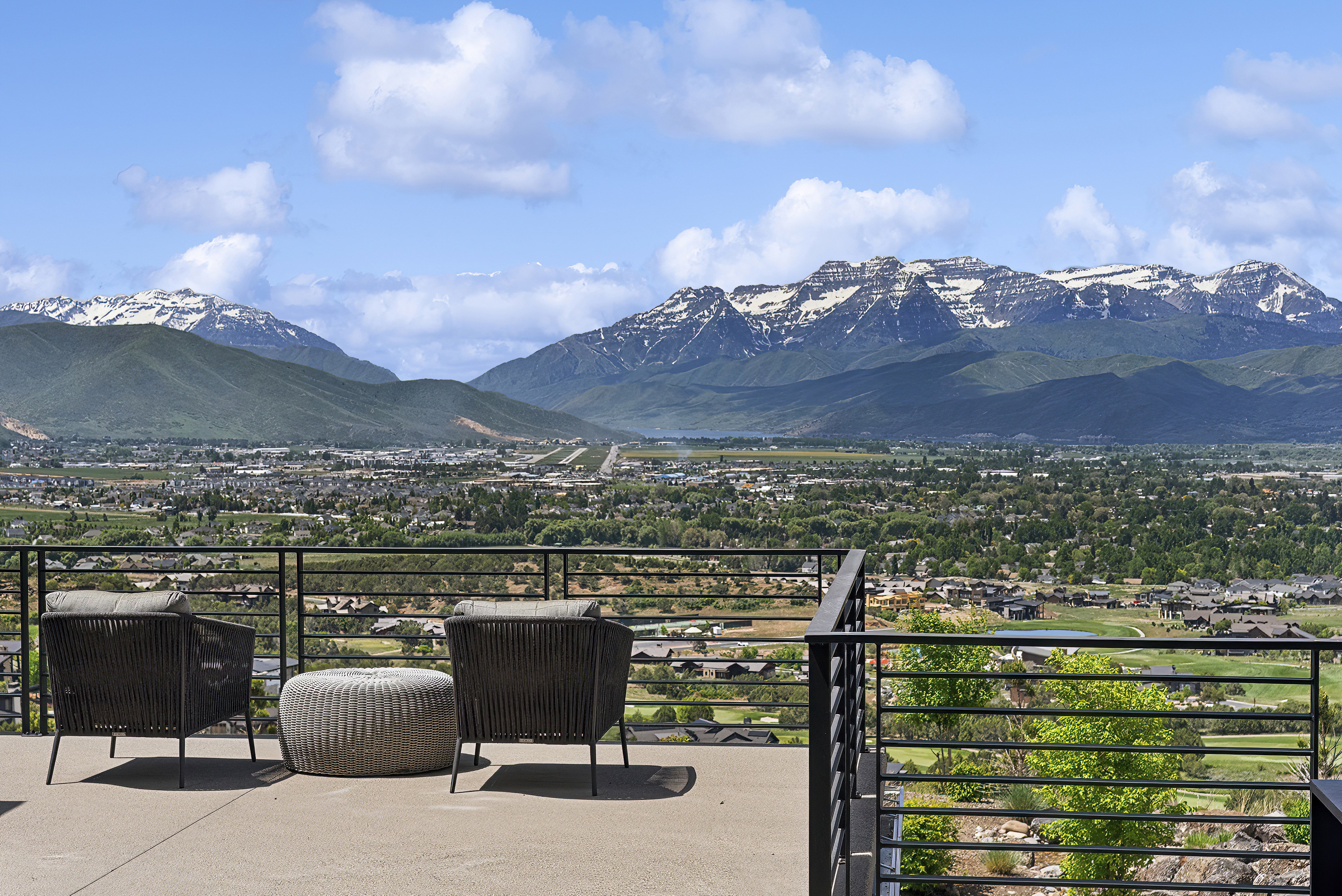 Expansive outdoor patio with a concrete surface and a black horizontal bar railing system