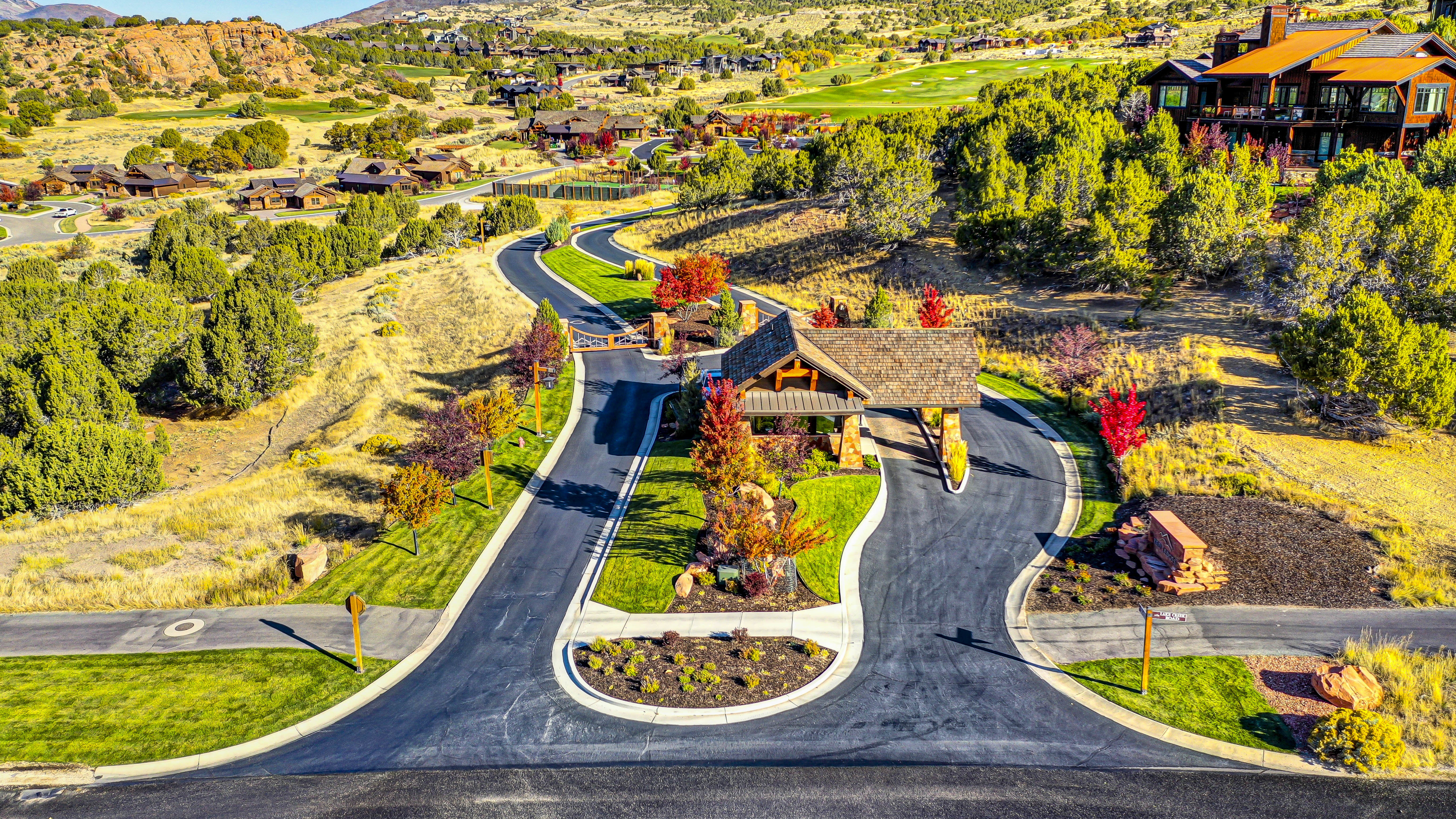 Gated community entrance featuring a timber and stone archway